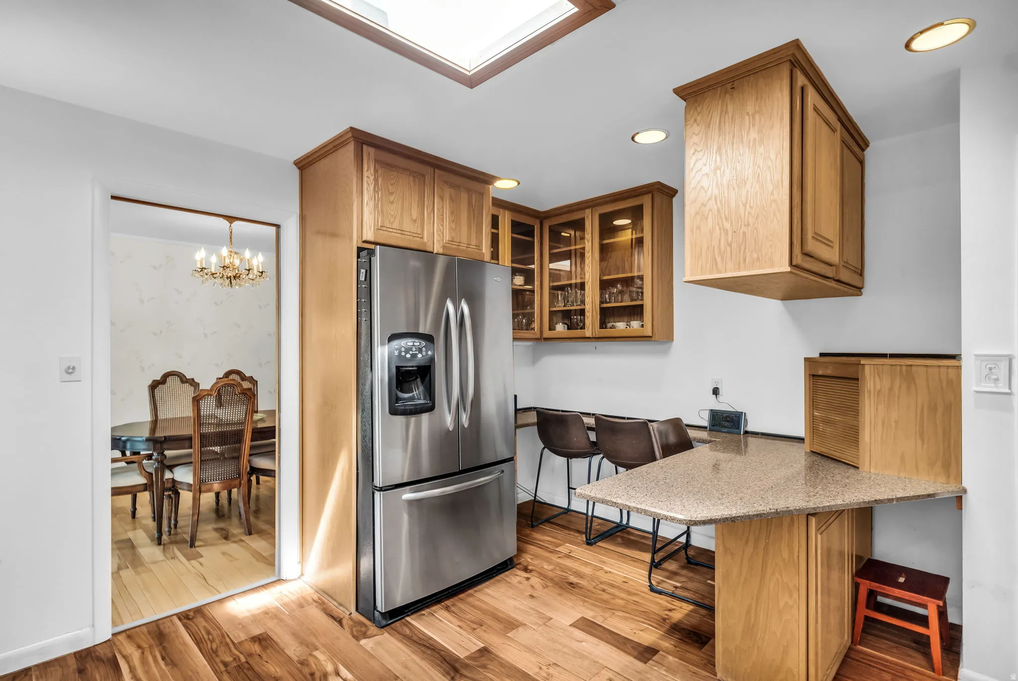 Kitchen featuring a skylight, wood-finish flooring, and built-in wood cabinetry