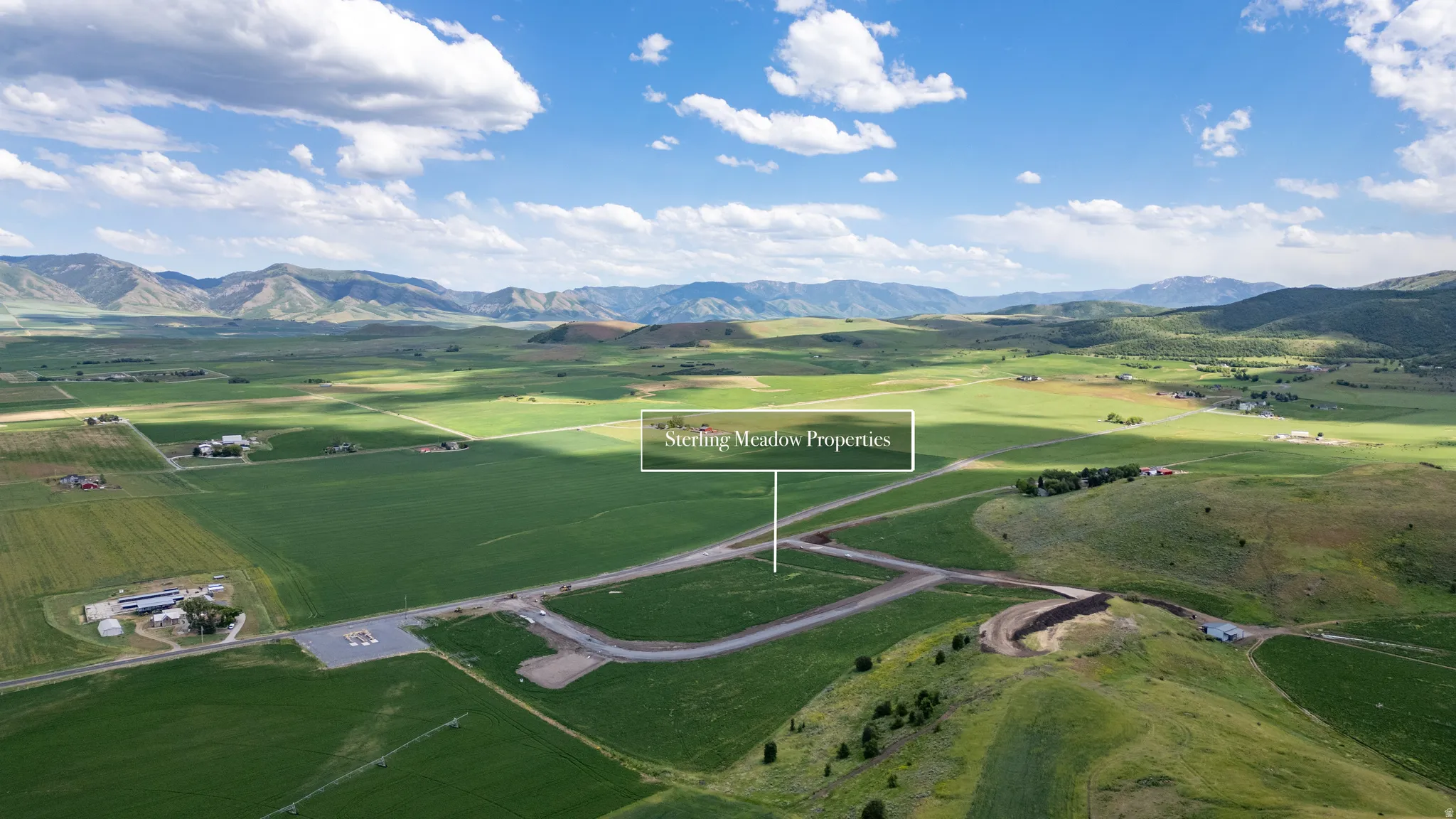 Expansive open terrain featuring established roadways and distant mountain ranges