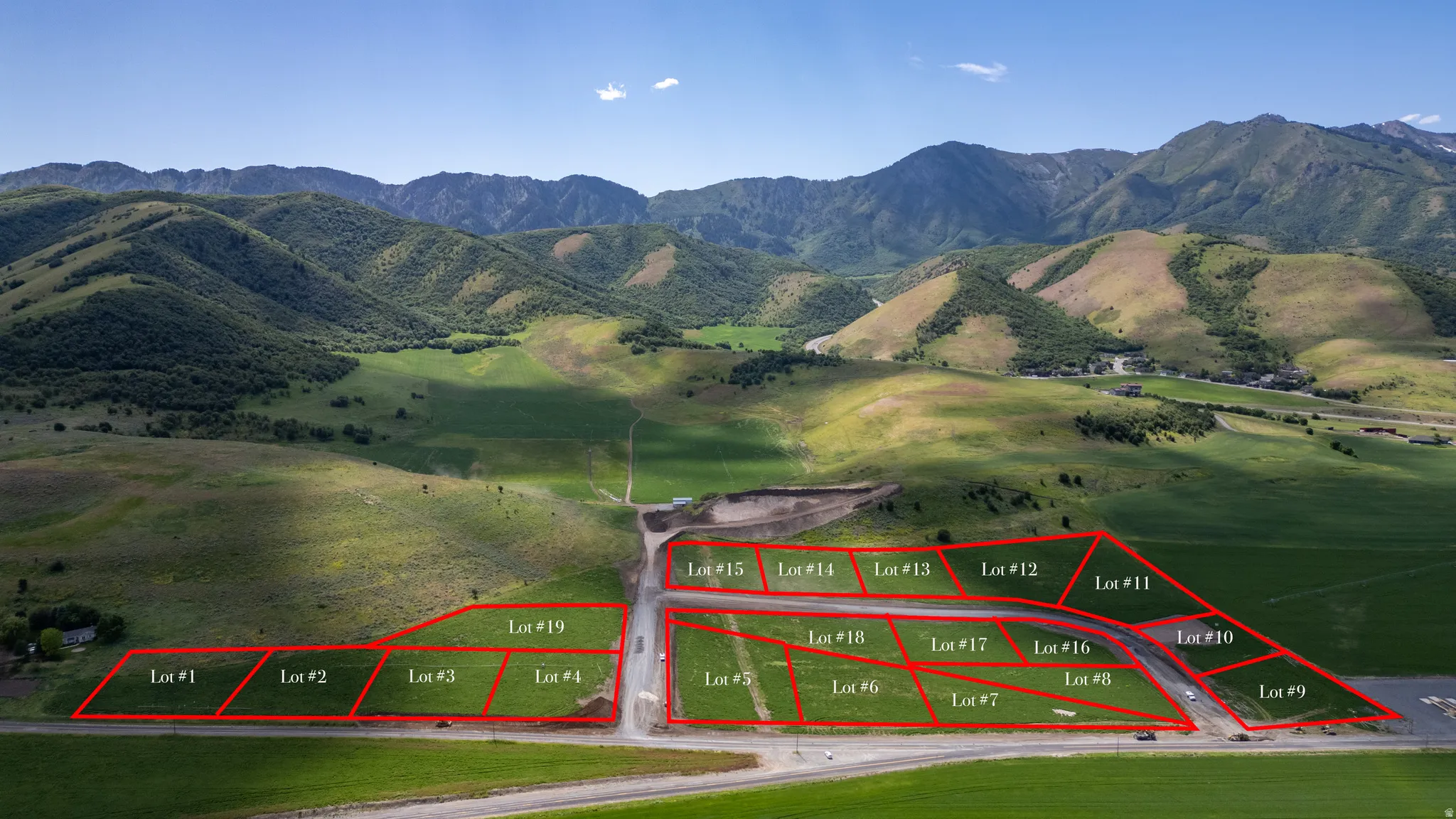 Expansive land parcels outlined in red, set against a backdrop of rolling green hills and distant mountains