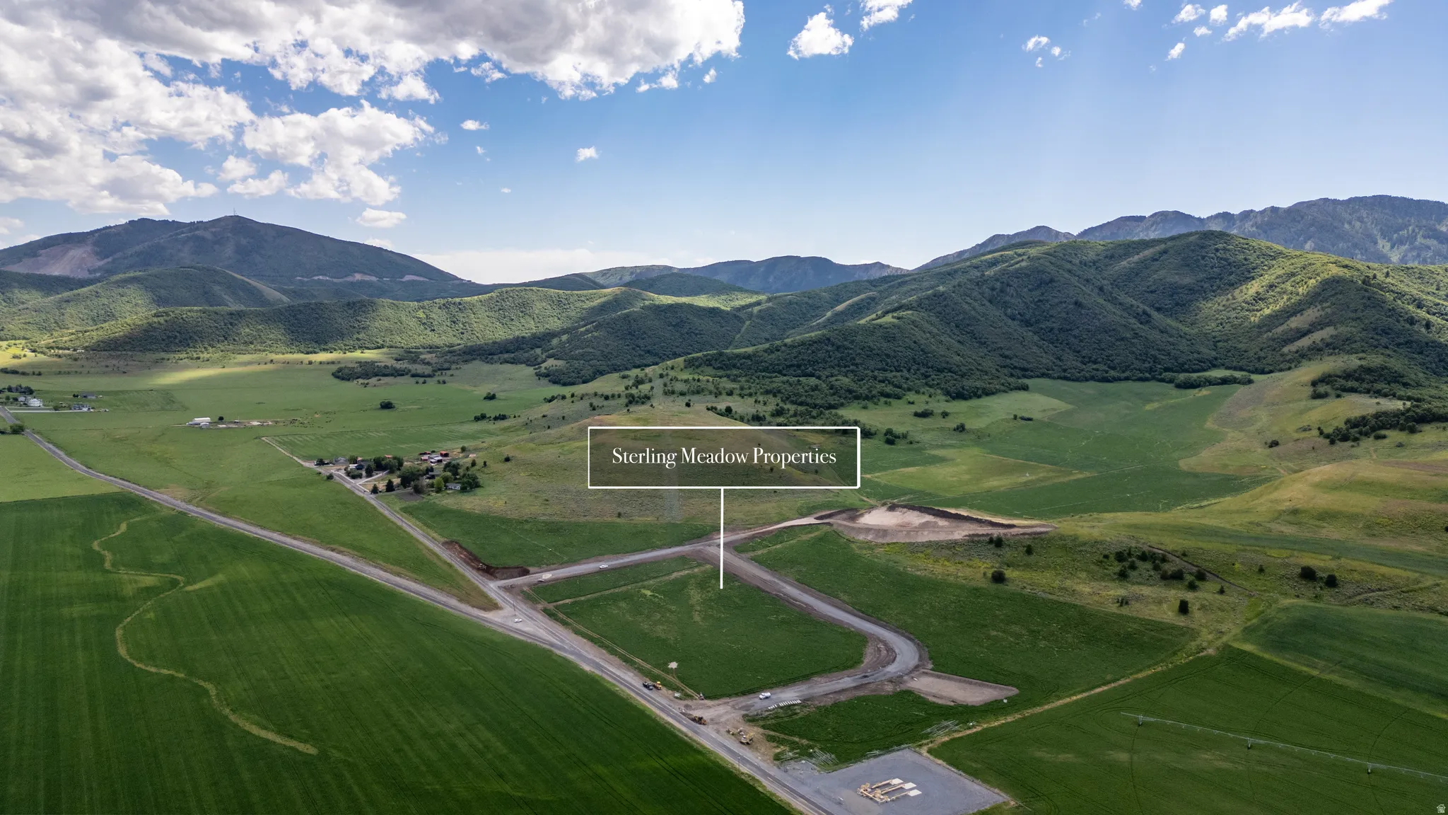 Expansive land parcels situated amidst rolling green hills and distant mountains