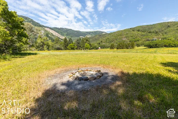 Expansive grass field featuring a stone-lined fire pit
