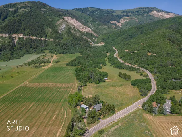 Expansive mountainous landscape featuring lush green foliage and agricultural fields