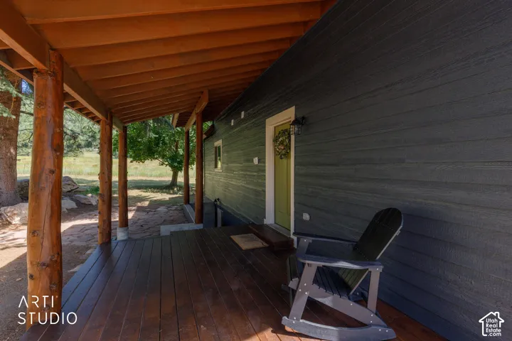 Inviting covered porch featuring natural wood posts and a rich wood-finish deck