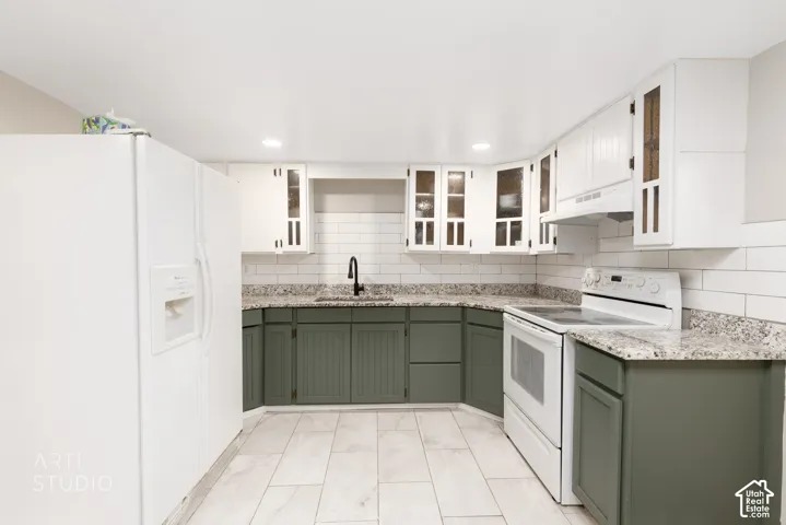 Kitchen featuring two-tone cabinetry, light-toned countertops, subway tile backsplash, recessed lighting, and tile flooring