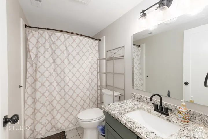 Bathroom vanity featuring a speckled countertop, integrated white sink, and matte black faucet