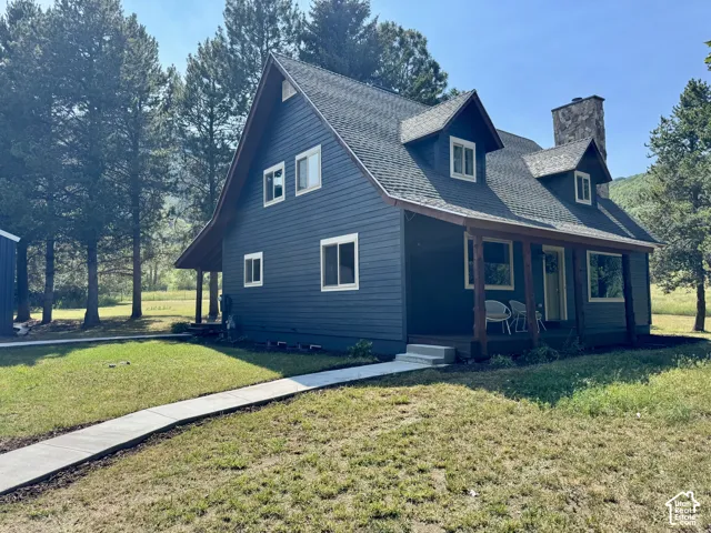 Dark blue siding exterior with a covered porch featuring wood support beams