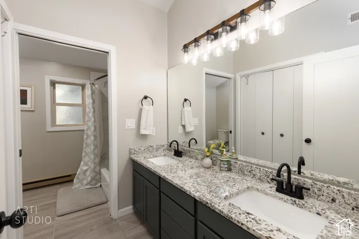 Dual vanity featuring speckled granite countertops and matte black fixtures