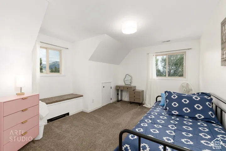 Carpeted bedroom with white walls and sloped ceilings