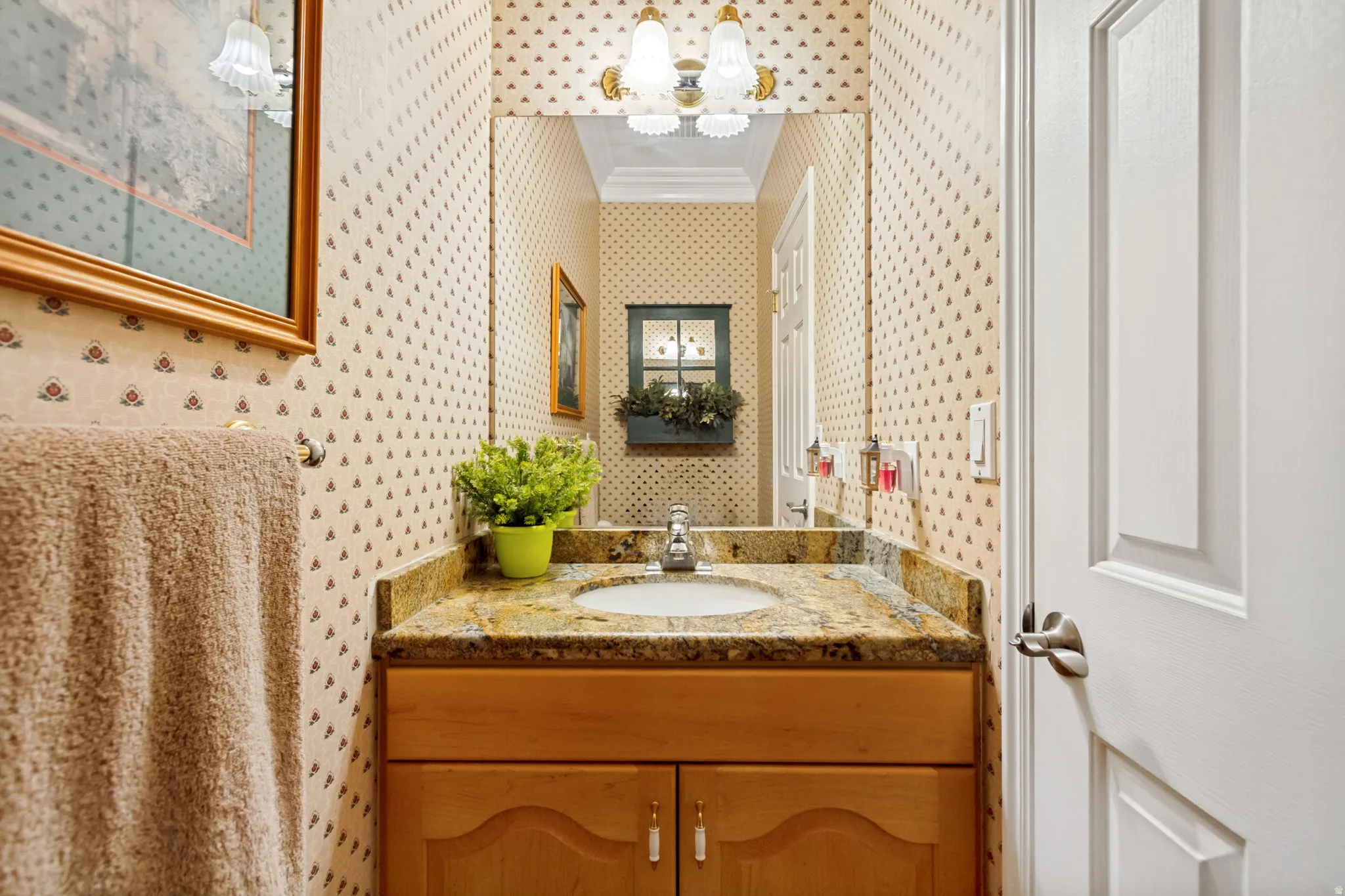 Vanity with a granite-finish countertop, undermount sink, and wood-finish cabinetry