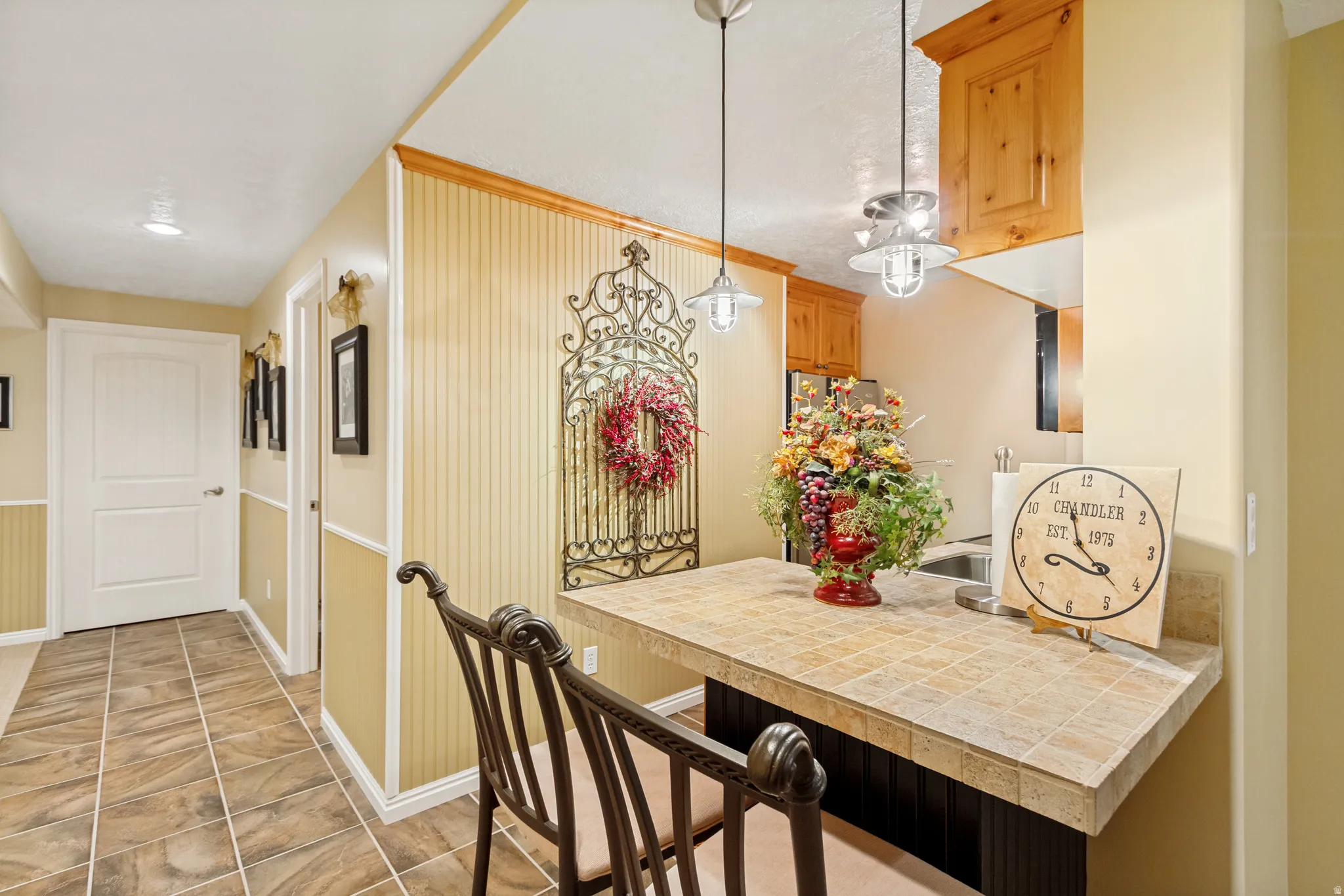 Kitchenette breakfast bar with tiled countertop and built-in wood cabinetry
