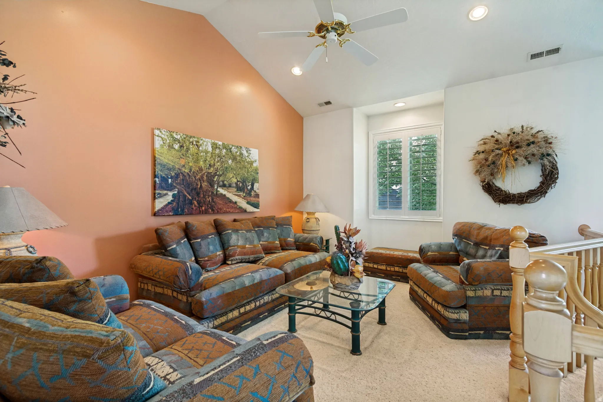 Vaulted ceiling with a ceiling fan, recessed lighting, and a window with plantation shutters