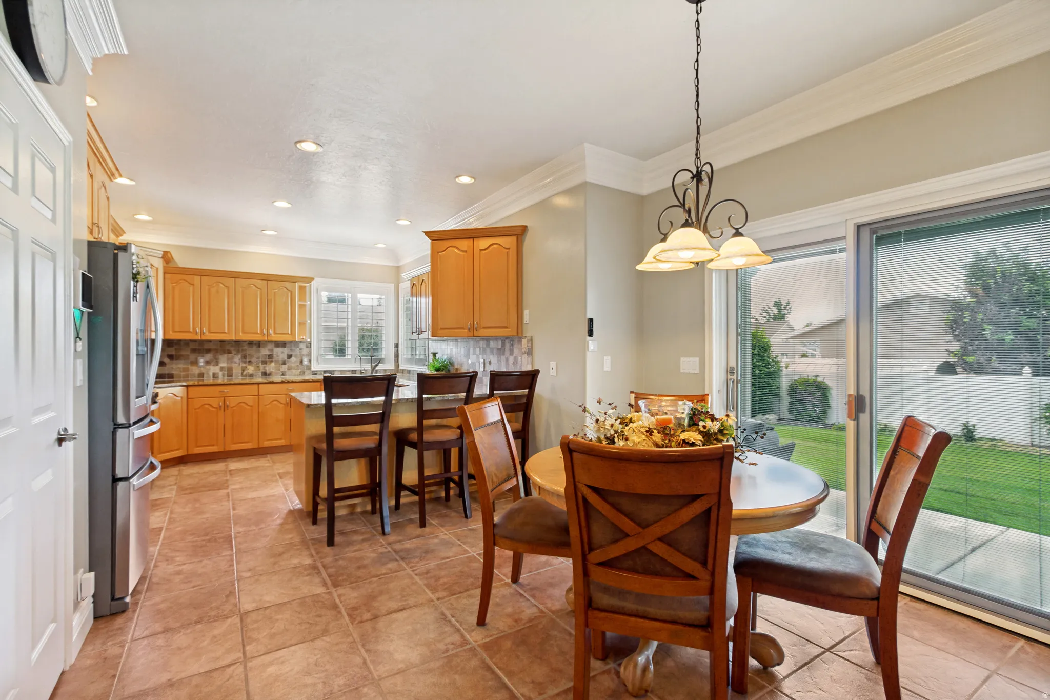 Kitchen area featuring warm wood cabinetry, a tiled backsplash, and recessed lighting