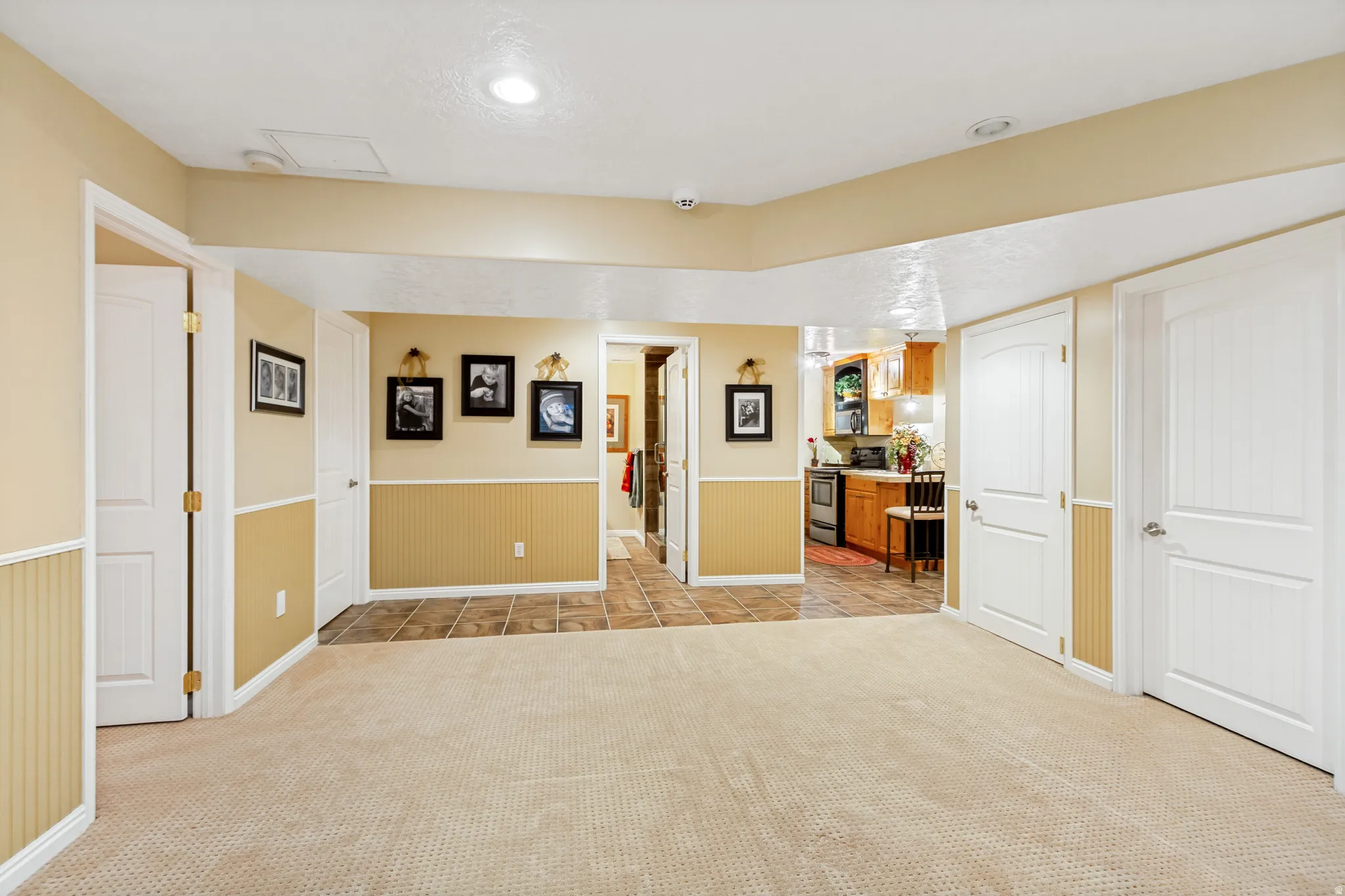 Spacious room featuring neutral carpeting, recessed lighting, and white trim