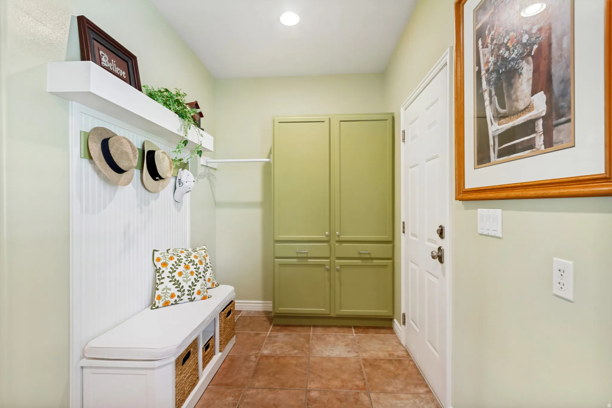 Entryway featuring an integrated bench with storage, beadboard paneling, and an overhead shelf