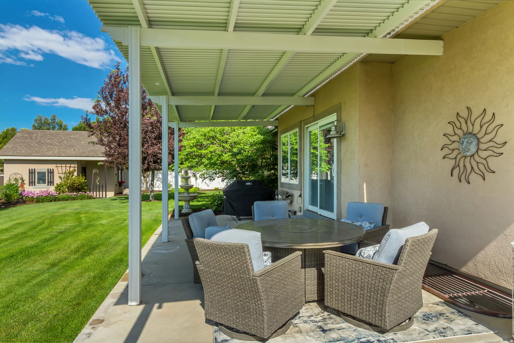 Covered patio with concrete flooring, stucco exterior, and sliding glass doors