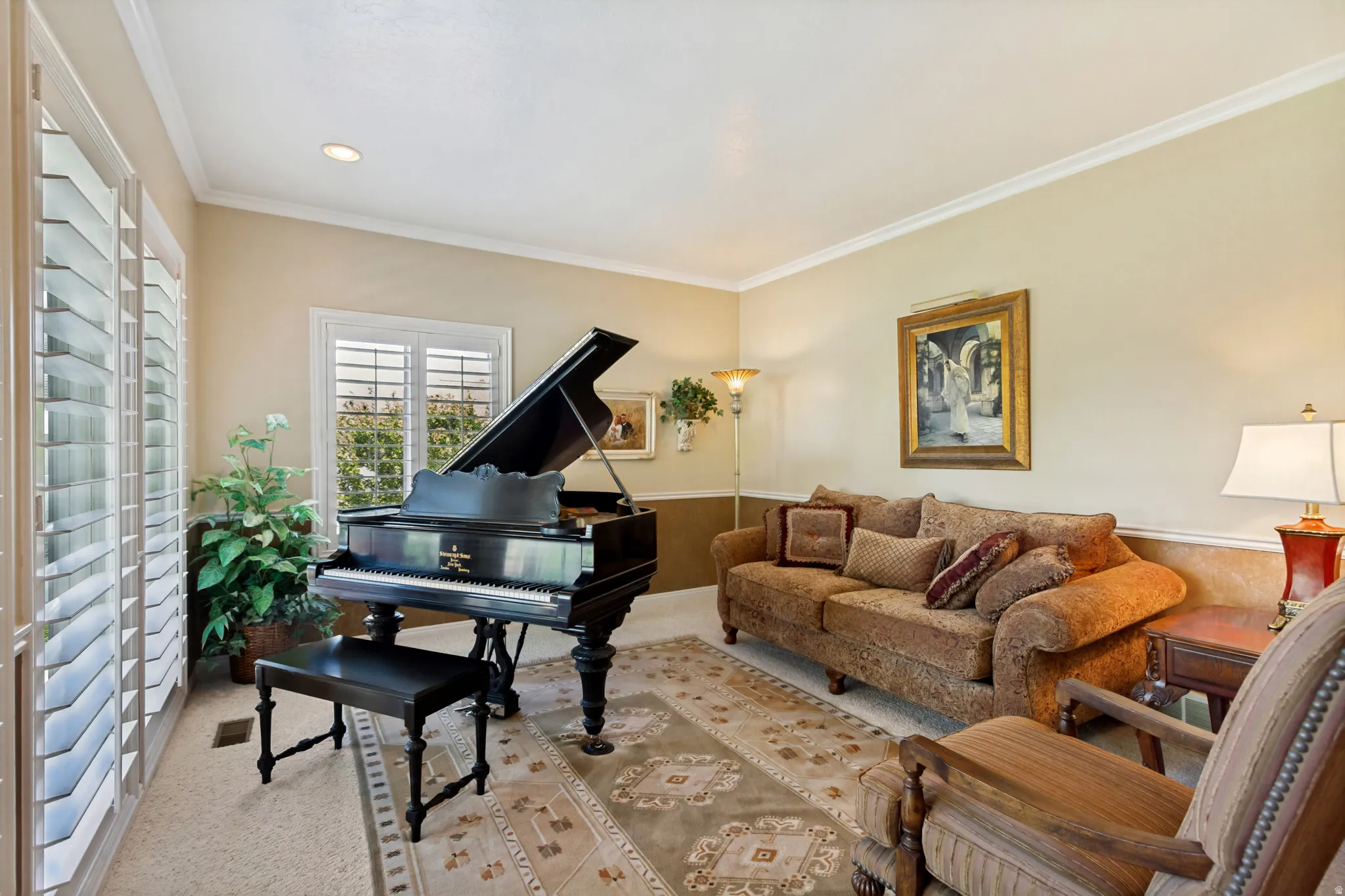 Spacious room featuring neutral wall tones, crown molding, plantation shutters, recessed lighting, and carpet flooring
