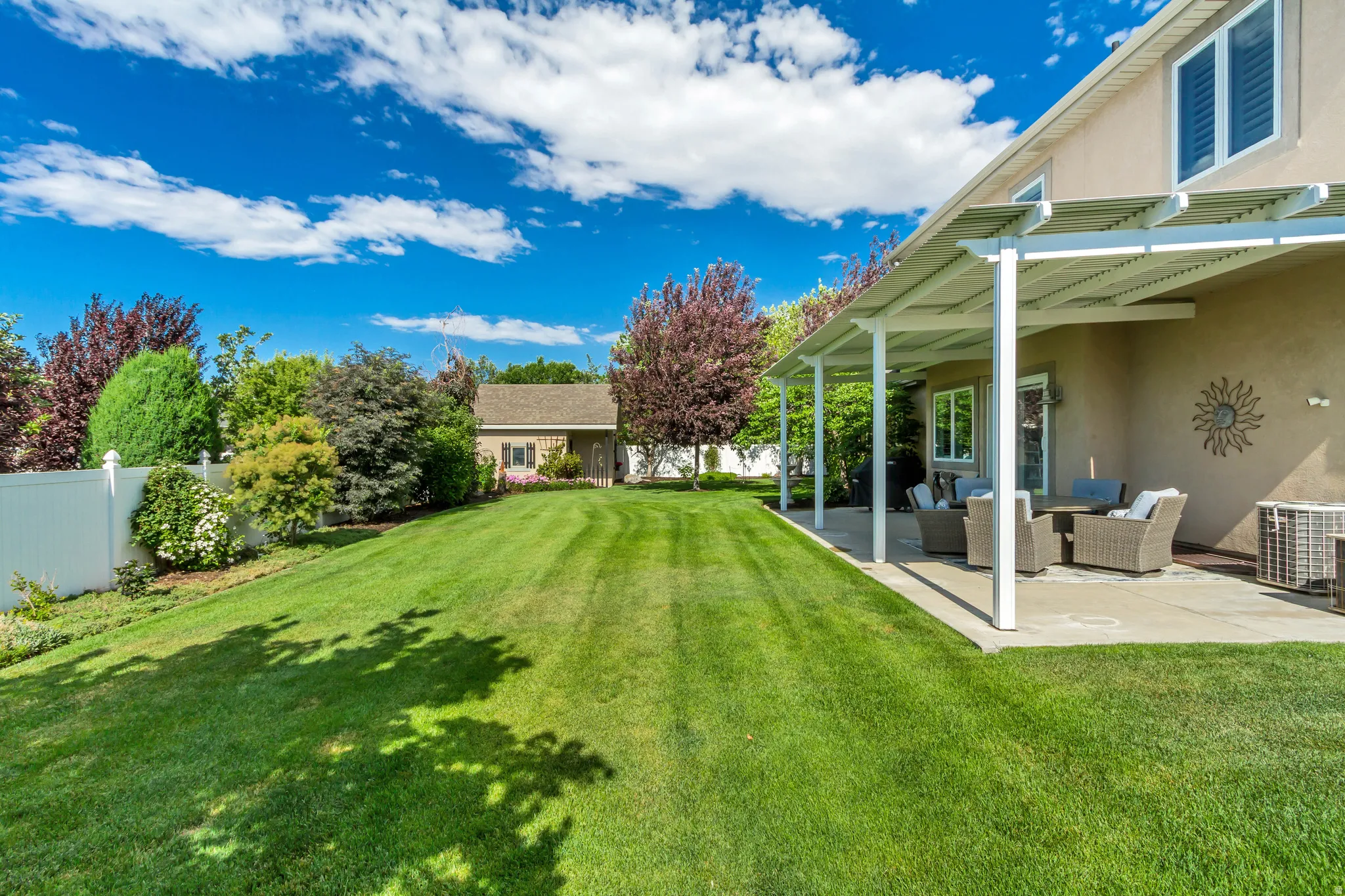 Expansive backyard featuring a long, level lawn and mature perimeter trees