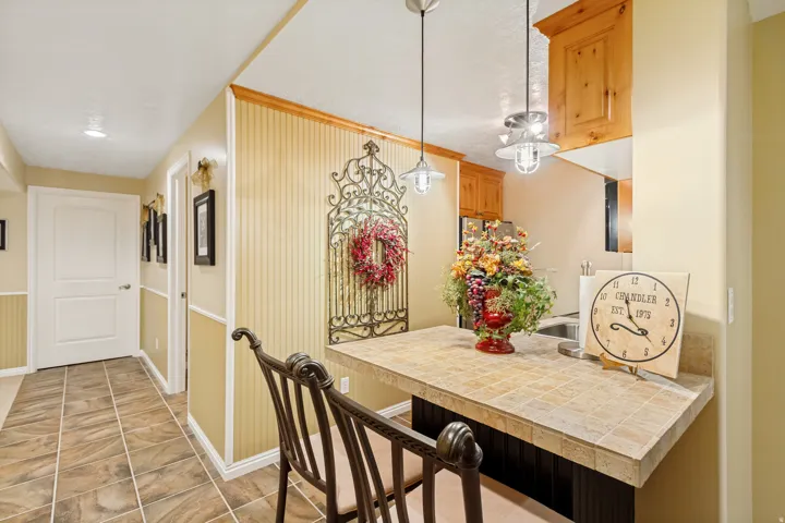 Kitchenette breakfast bar with tiled countertop and built-in wood cabinetry