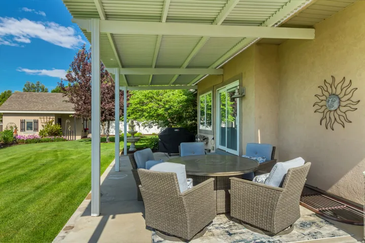 Covered patio with concrete flooring, stucco exterior, and sliding glass doors
