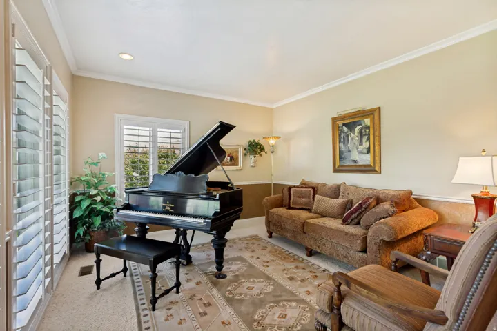Spacious room featuring neutral wall tones, crown molding, plantation shutters, recessed lighting, and carpet flooring