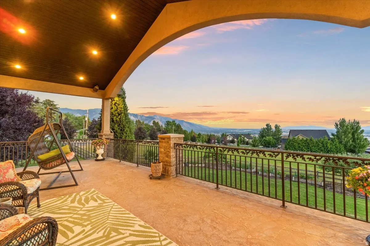 Covered patio with recessed lighting, stamped concrete flooring, and wrought iron railing with decorative leaf details