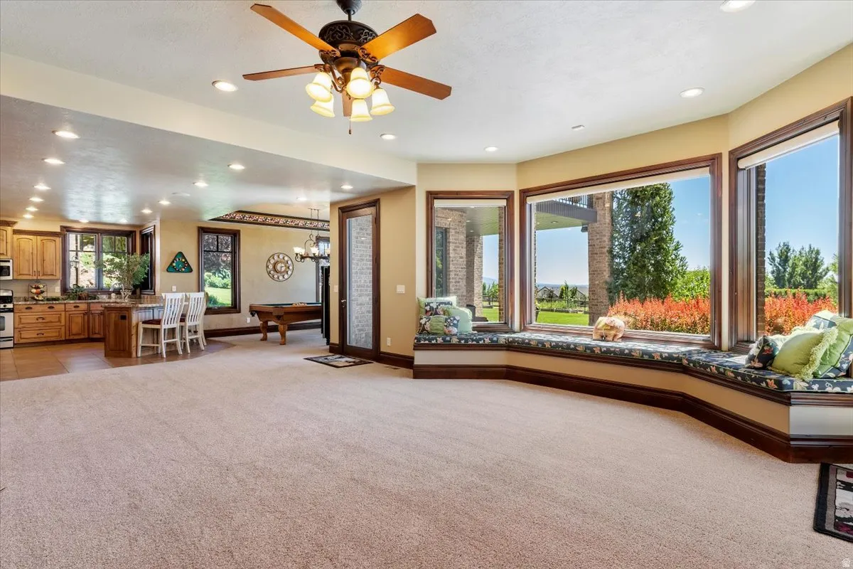 Spacious room featuring a bay window with integrated bench seating, recessed lighting, and a ceiling fan