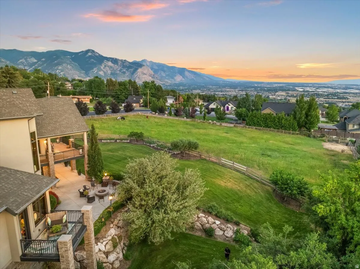 Outdoor living at its finest, featuring multiple patios, terraced landscaping, and a substantial grassy expanse