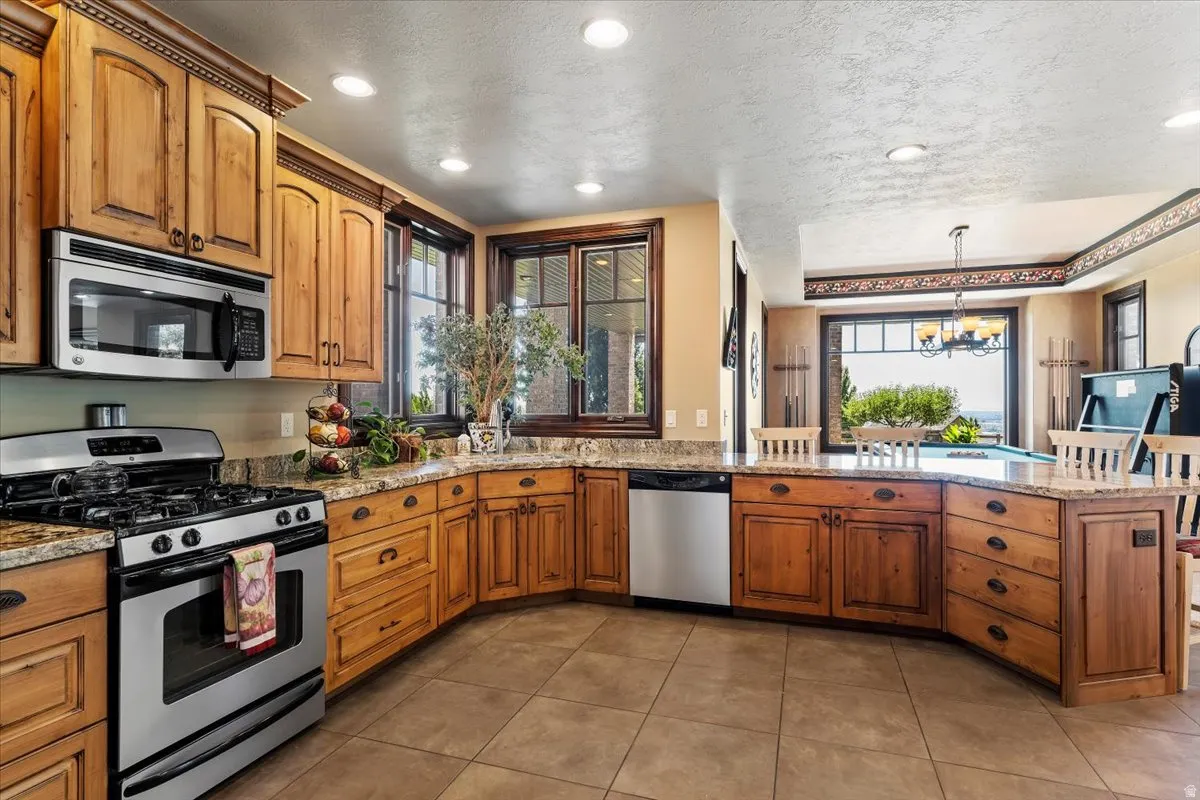 Kitchen featuring warm wood cabinetry, stainless steel appliances, and granite countertops