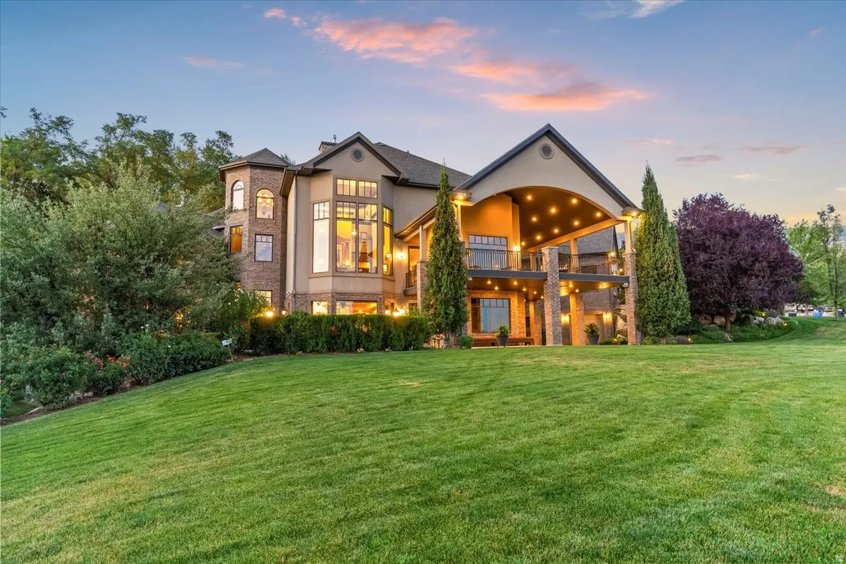 Expansive rear facade featuring multiple levels, extensive window arrangements, and a covered patio with integrated lighting