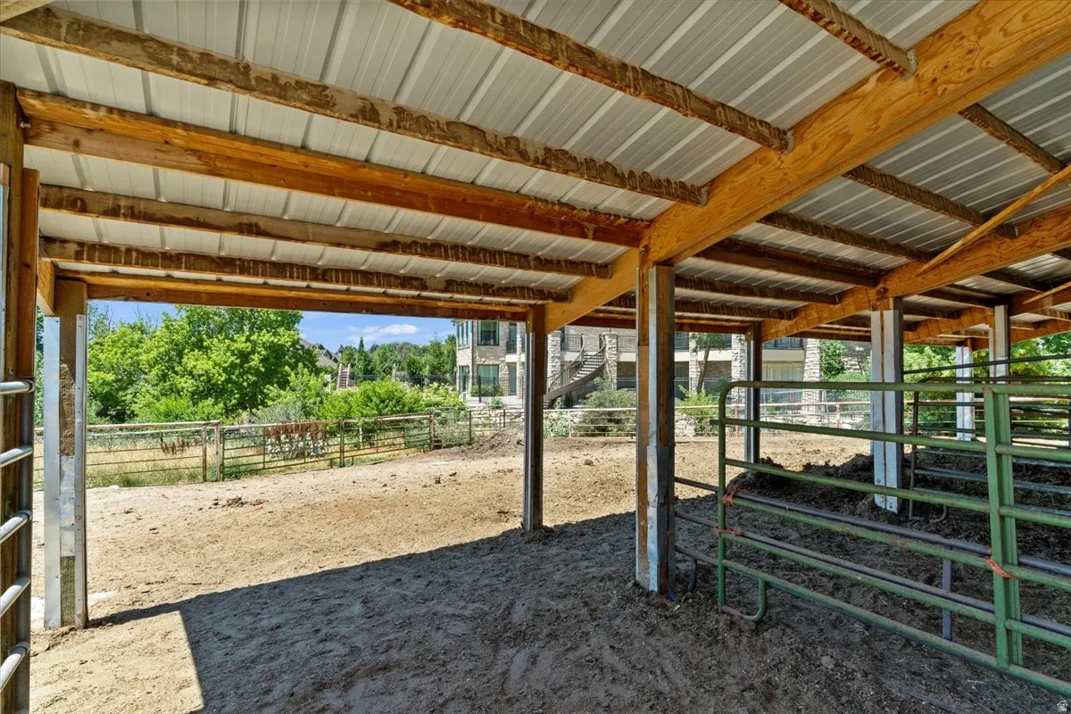 Open-air barn structure featuring a corrugated metal roof and exposed wood beams