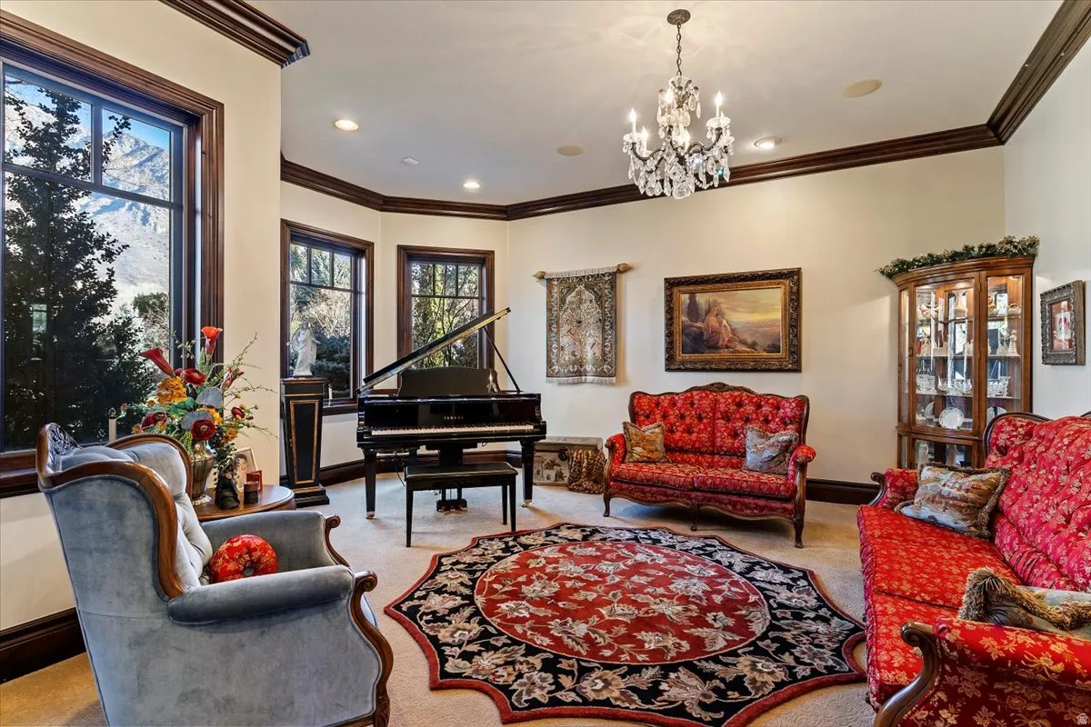 Elegant room featuring extensive dark wood trim, large windows, recessed lighting, and a crystal chandelier