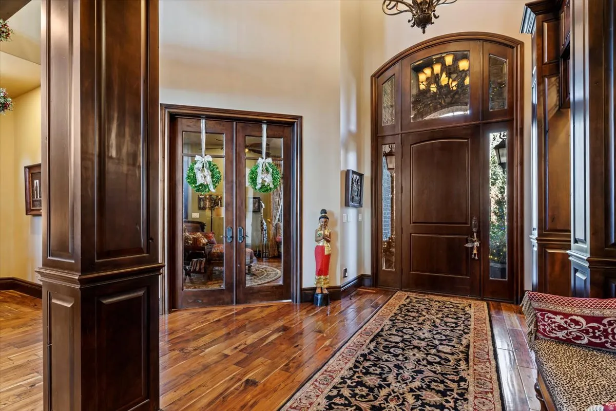 Grand entry featuring a solid wood door with arched transom and sidelight windows