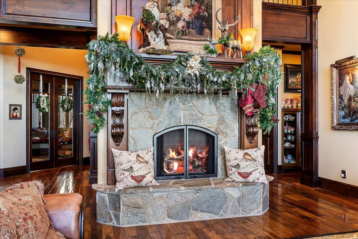 Stone fireplace with a hearth bench, featuring a wood mantel and decorative carvings