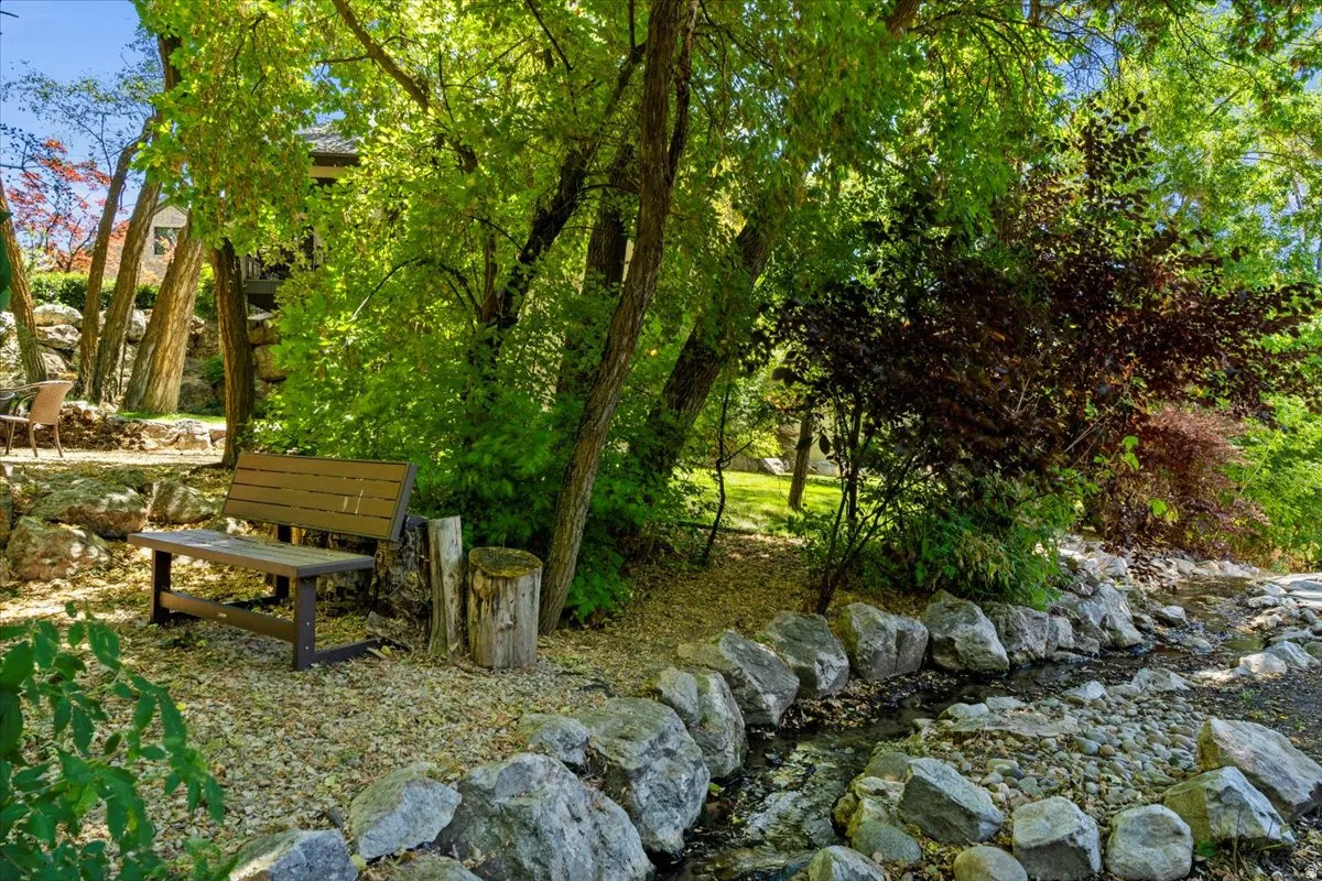 Naturalistic landscaping surrounded by Alder Creek, mature trees, private sitting areas, and year round color.
