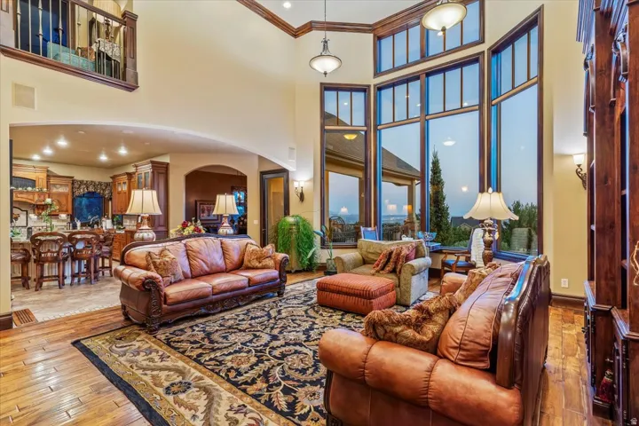 Great room featuring two-story ceilings, extensive wood trim details, and large picture windows