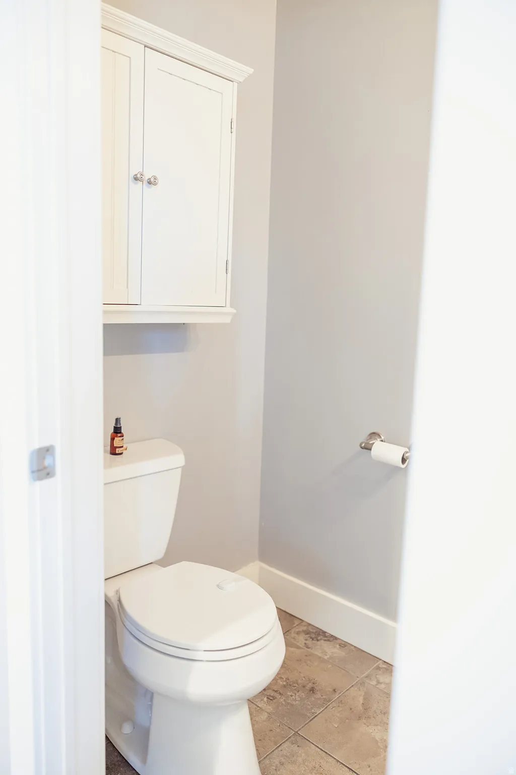 Neutral wall color with white trim and a wall-mounted storage cabinet featuring polished hardware