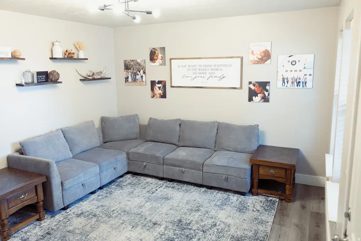 Spacious interior room featuring light-toned walls and wood-finish flooring