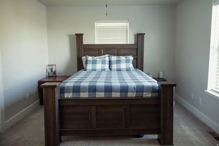 Carpeted bedroom with neutral wall paint and white trim