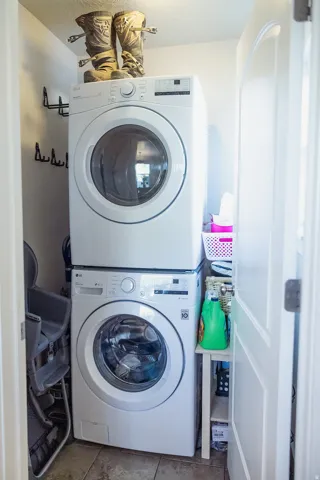 Dedicated laundry area featuring stacked front-load washer and dryer units