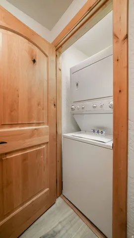 Dedicated laundry area featuring a stacked washer and dryer unit