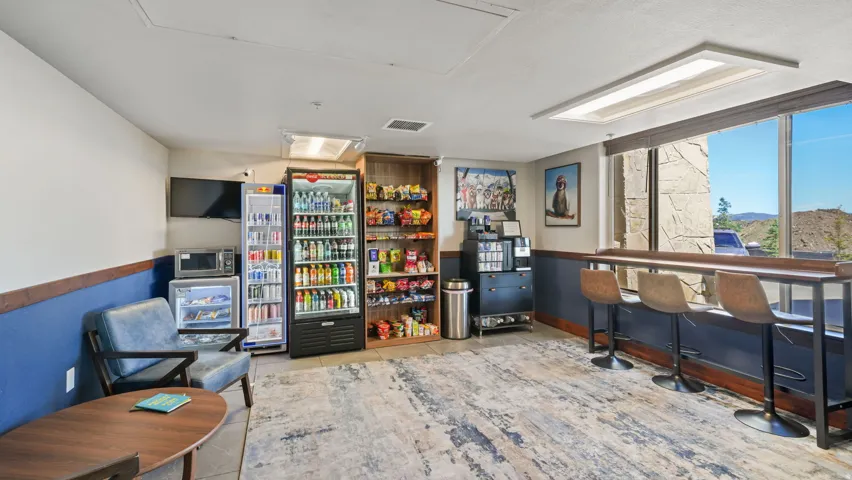 Amenity space featuring large windows, a window-facing bar counter with three bar stools, and a wood-finish accent wall