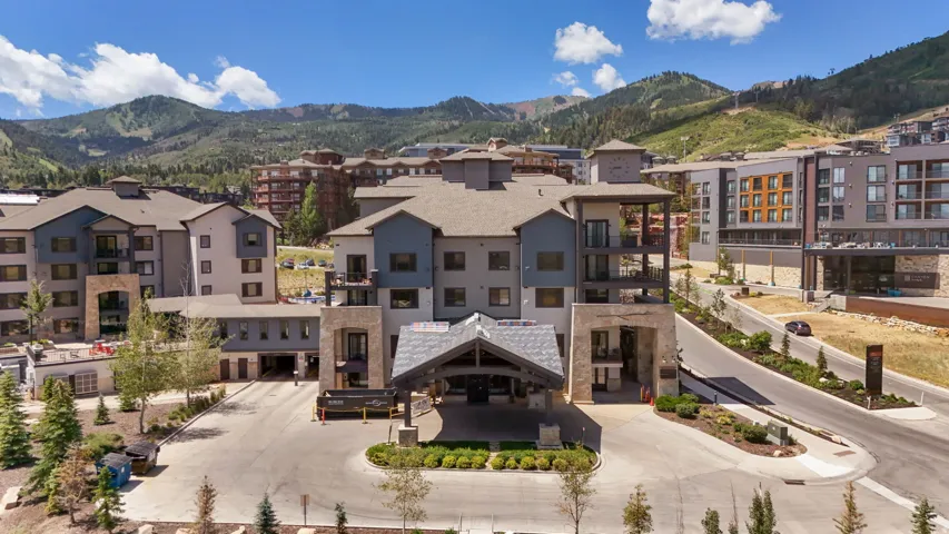 Multi-story residential building featuring a stone and wood-look exterior