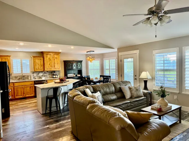 Open-concept living area featuring wood-finish flooring and vaulted ceilings