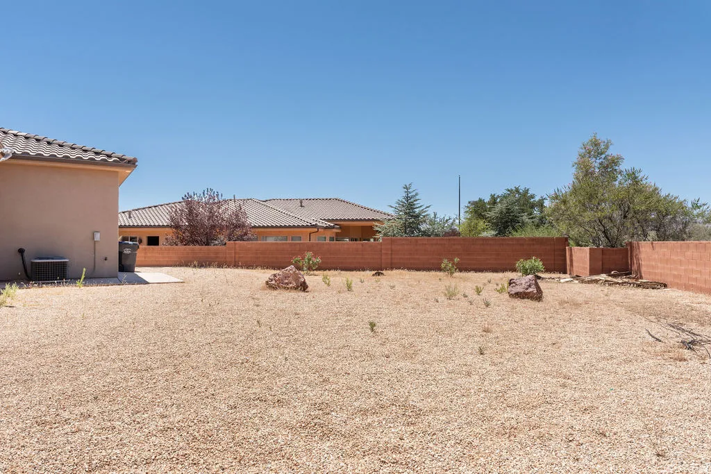Expansive backyard featuring a gravel landscape and a block wall perimeter