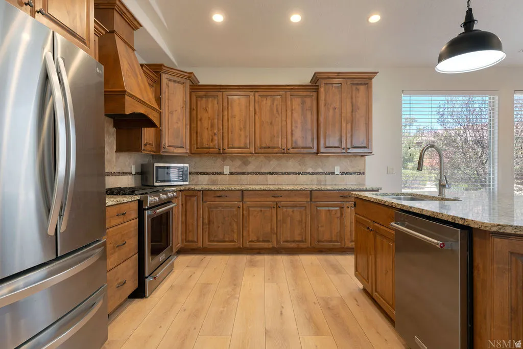 Kitchen featuring wood-finish flooring, recessed lighting, and a window with blinds