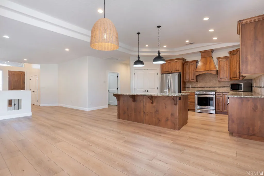 Spacious kitchen with wood-finish cabinetry, granite countertops, and stainless steel appliances