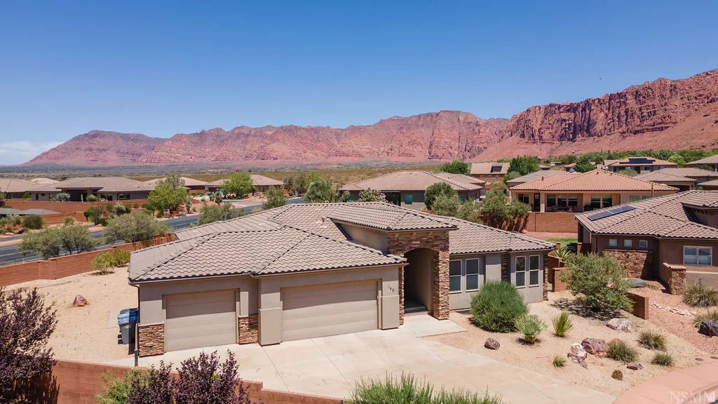 Southwest-style residence featuring a tile roof and two-car garage
