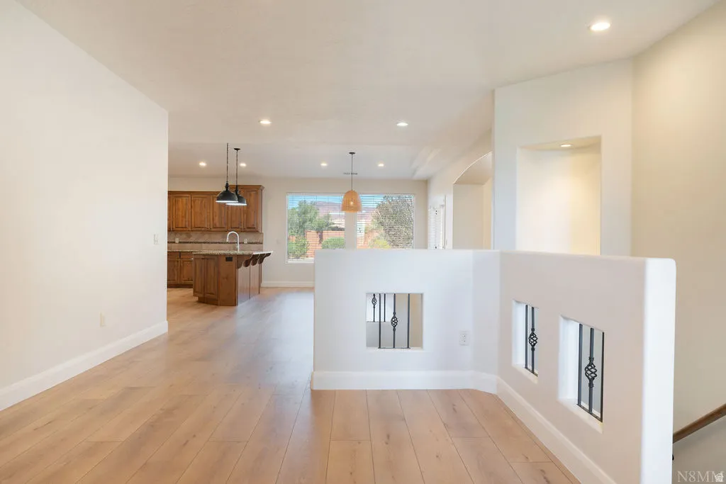 Light wood-finish flooring extending through an open-concept living area