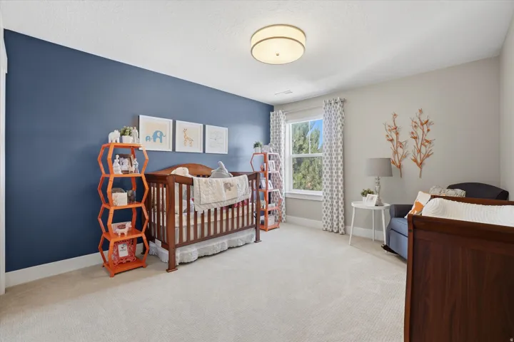 Spacious room featuring a large window, light-colored carpeting, a contemporary ceiling fixture, and a two-tone wall design with a prominent accent wall