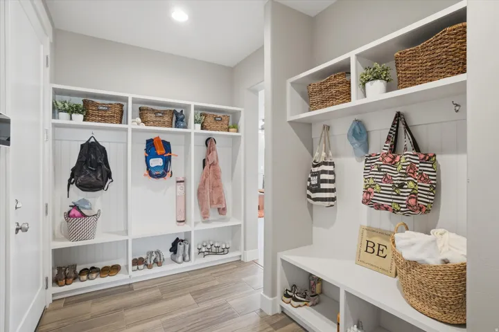 Built-in white cubbies with beadboard backing, integrated shelving, and bench seating